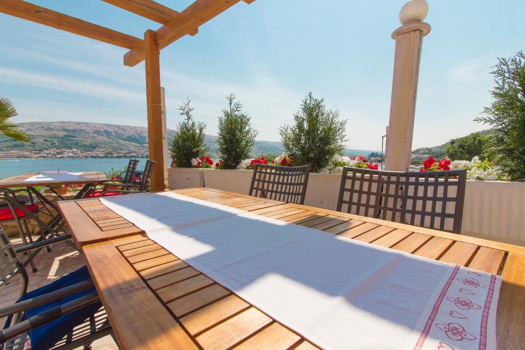 a wooden table on a deck with a view of the water at Boutique Villa Revelin in Pag