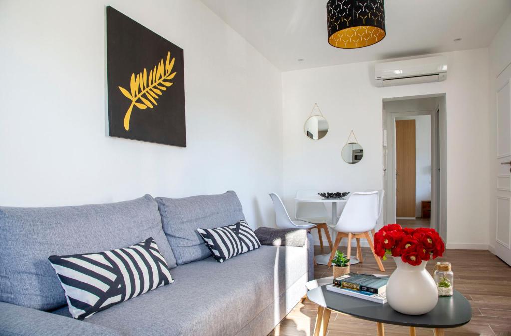 Totolulu Cannes Smart في كان: غرفة معيشة مع أريكة زرقاء وطاولة