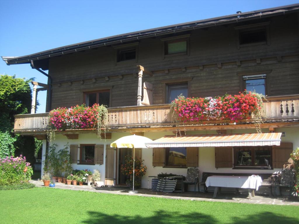 a house with a balcony with flowers on it at Landhaus Sommerau in Reith bei Kitzbühel