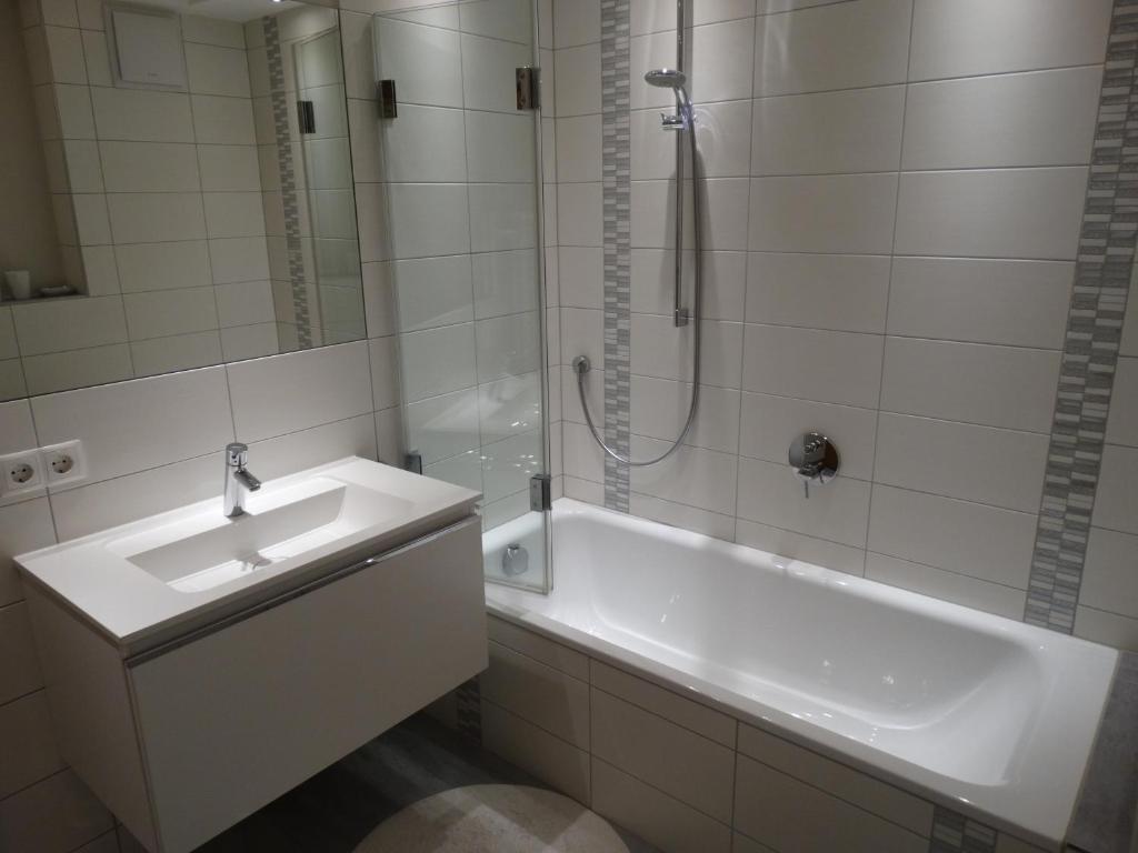 biała łazienka z umywalką i prysznicem w obiekcie Landhaus Sommerau w mieście Reith bei Kitzbühel