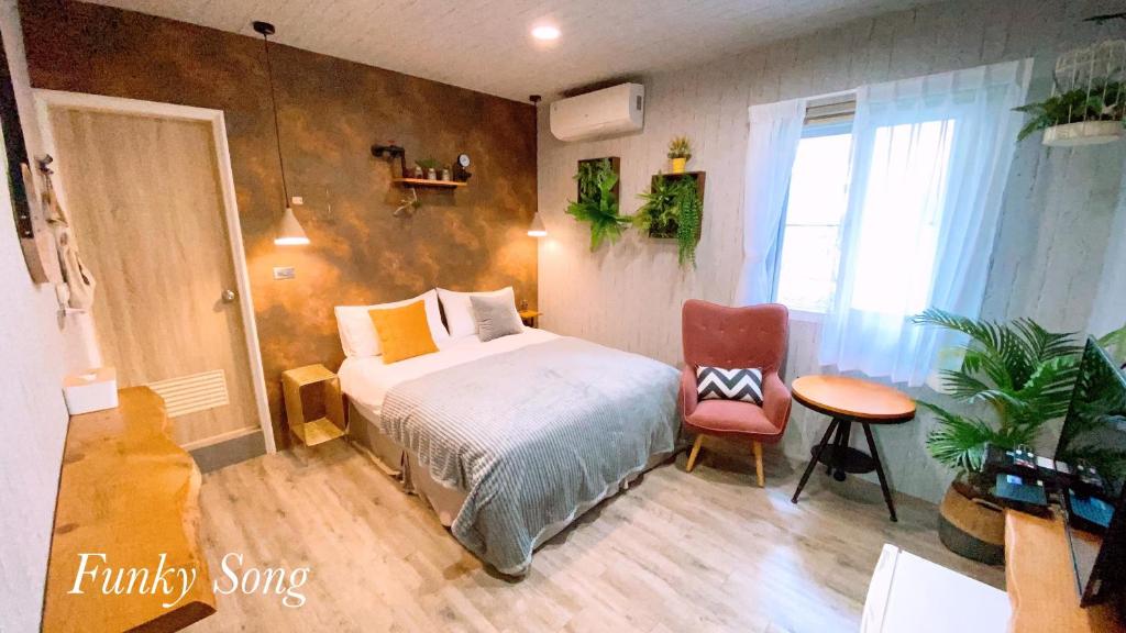 台南的住宿－Funky Song 放輕鬆，卧室配有1张床、1张桌子和1把椅子