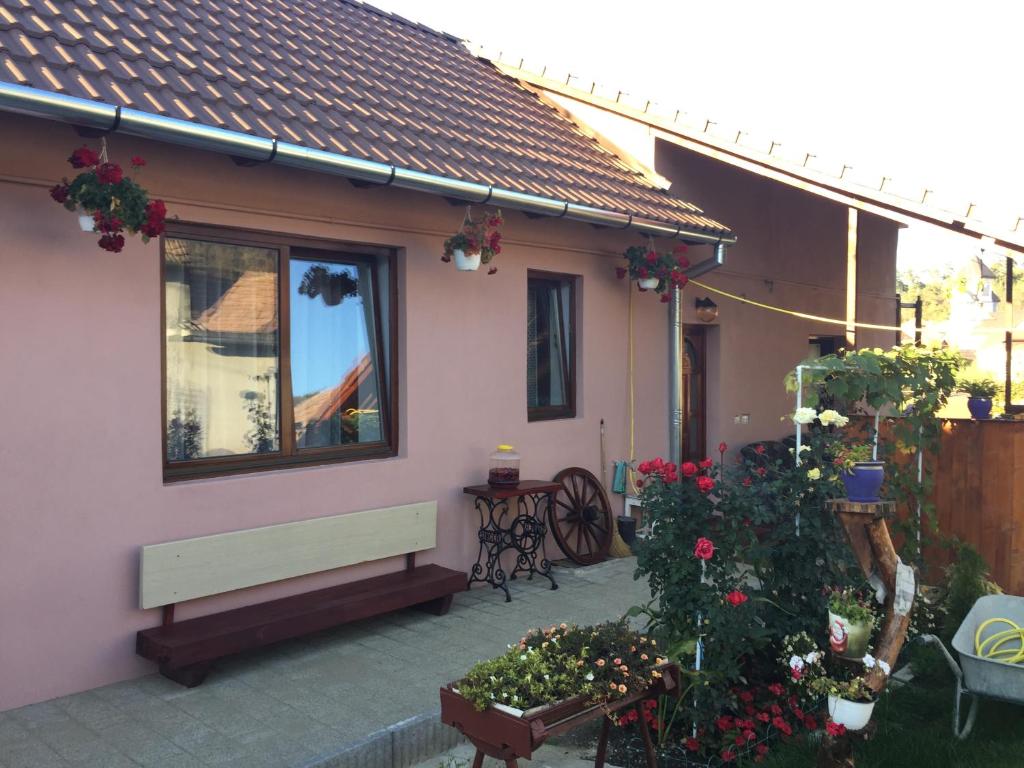 una casa con un banco y flores en un patio en Casa rustica cu terasa, en Mediaş