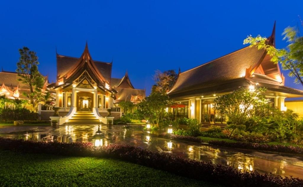 Una casa bajo la lluvia por la noche con luces en Sireeampan Boutique Resort and Spa, en Chiang Mai