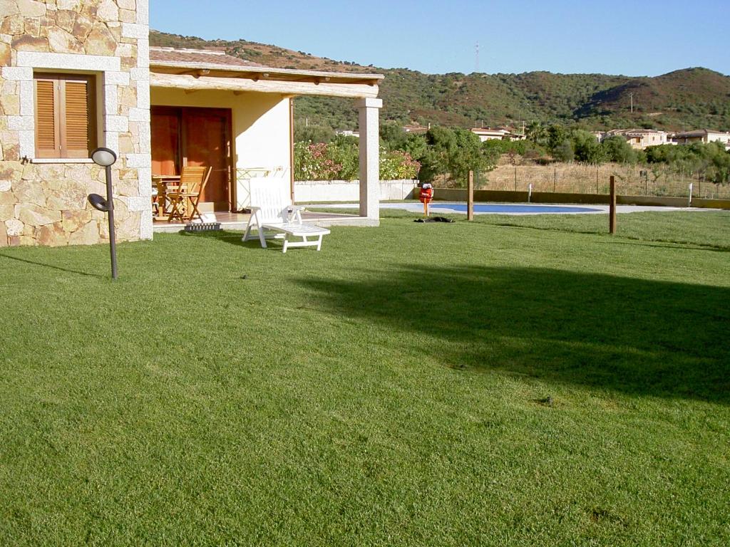 Una casa con un patio de césped con una persona al fondo. en VILLA ELEONORA-IUN-P6104, en San Teodoro