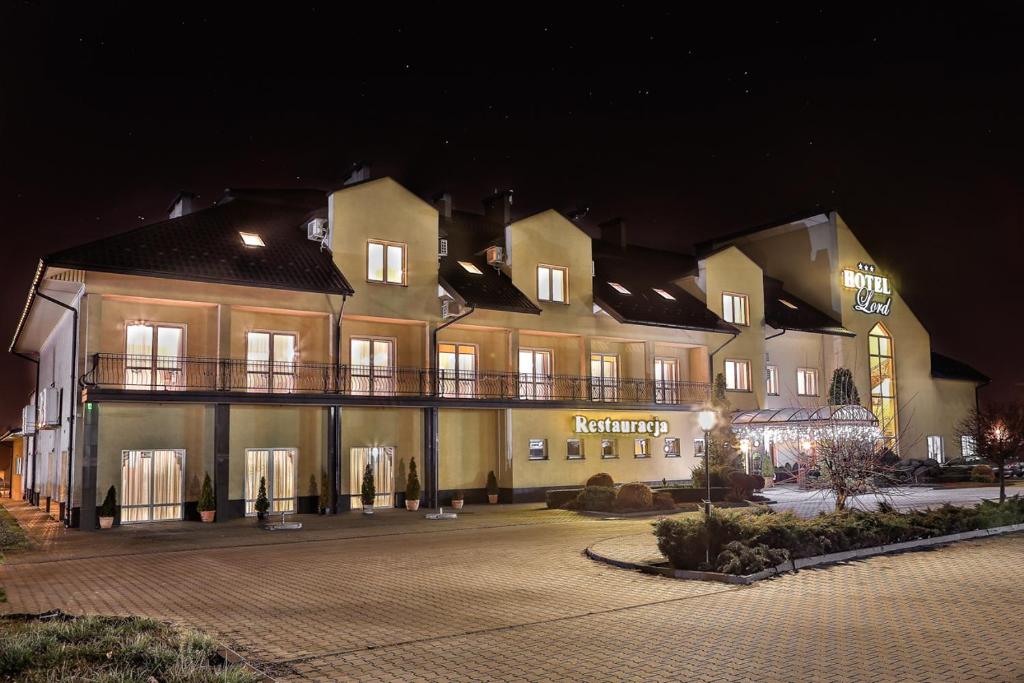 un gran edificio por la noche con sus luces encendidas en Hotel Lord Dębica, en Dębica