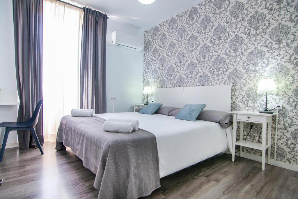 a bedroom with a large white bed and a chair at Kasa Katia Eco Guest House in Valencia