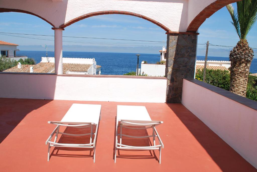 2 sillas y una mesa en un balcón con vistas al océano en Es Caials, en Cadaqués