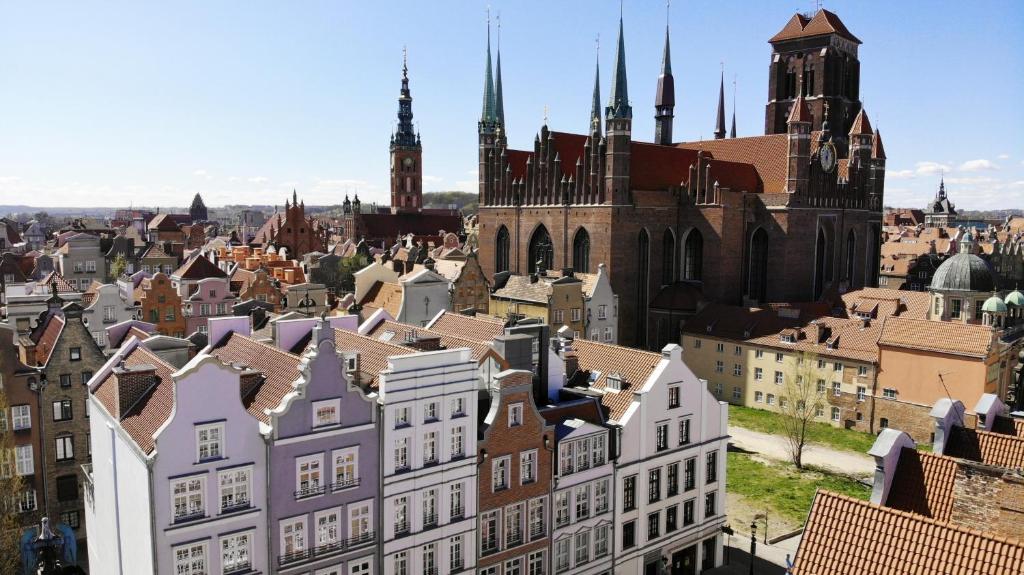 Blick auf eine Stadt mit Gebäuden und einer Kirche in der Unterkunft VIU Old Town Balcony in Danzig