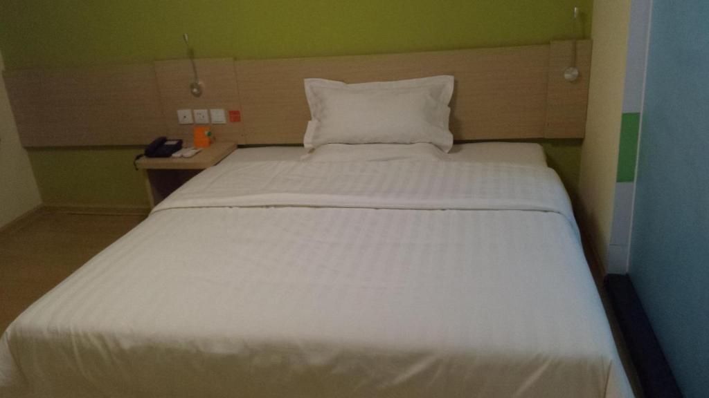a large white bed in a small room at 7Days Inn Nanan Shuitou southeast Fortune Plaza in Quanzhou