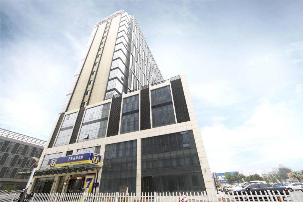 a tall building with a sign in front of it at 7Days Inn Qinhuangdao Railway Station in Qinhuangdao