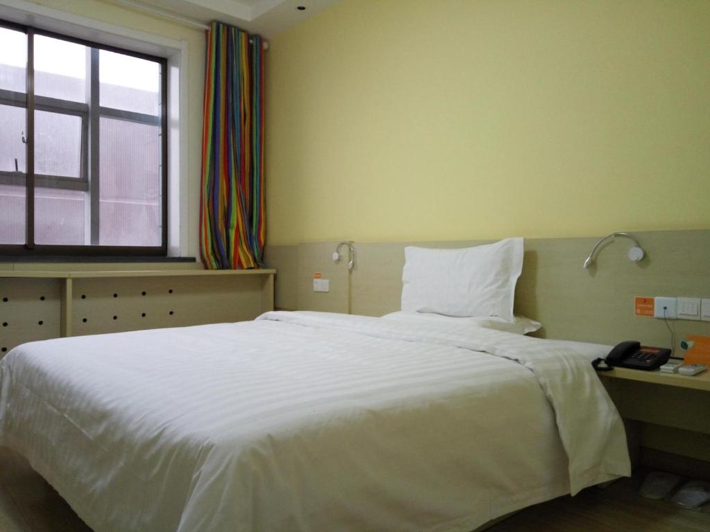 a bedroom with a large white bed and a window at 7Days Inn Yulin Guangji building in Yulin