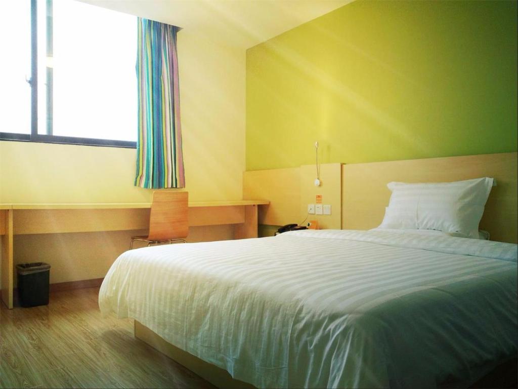 een slaapkamer met een groot bed en een raam bij 7Days Inn Shenzhen Shiyan in Longwancun