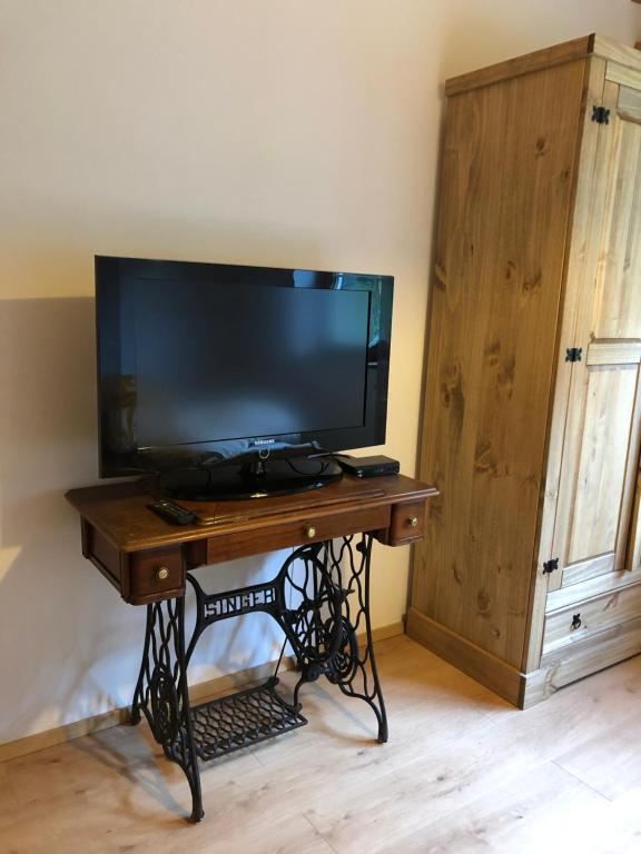 a tv on a stand with a table with a television at Sonniges Landhaus in den Hohen Tauern in Rauris
