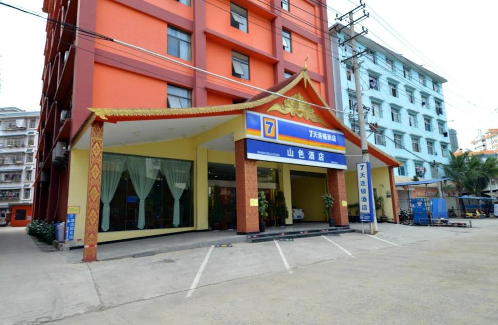 un edificio con una señal delante de él en 7Days Inn Xishuangbanna GaoZhuang West Shuangjing en Jinghong