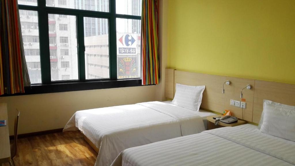 a hotel room with two beds and a window at 7Days Inn Huainan pedestrian street in Huainan