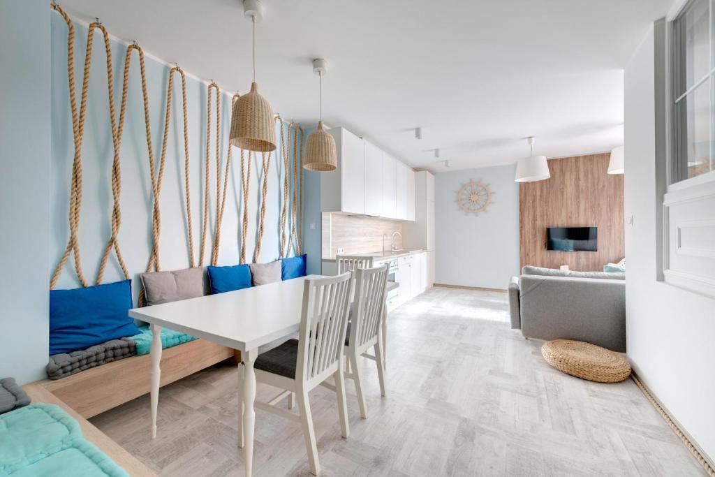 uma cozinha e sala de estar com mesa e cadeiras em 3 City Apartments - Admiralski em Gdansk
