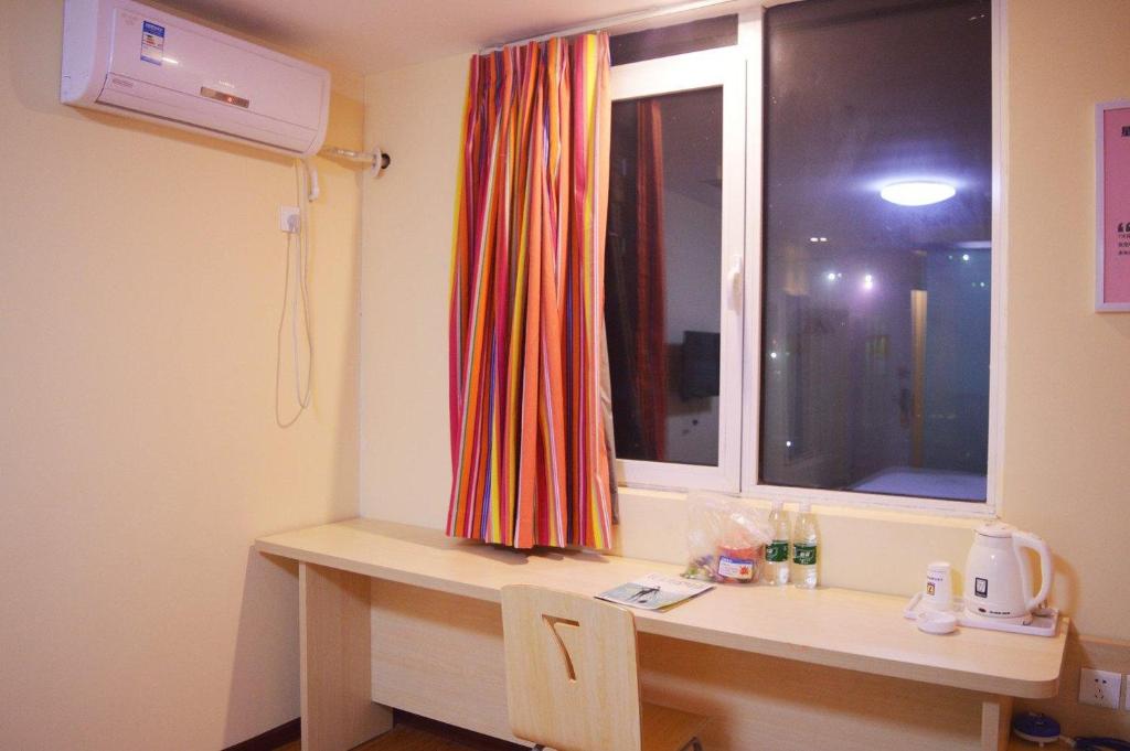 a room with a desk and a window with a window at 7Days Inn Shijiazhuang Friendship Avenue Jianguo Road in Shijiazhuang
