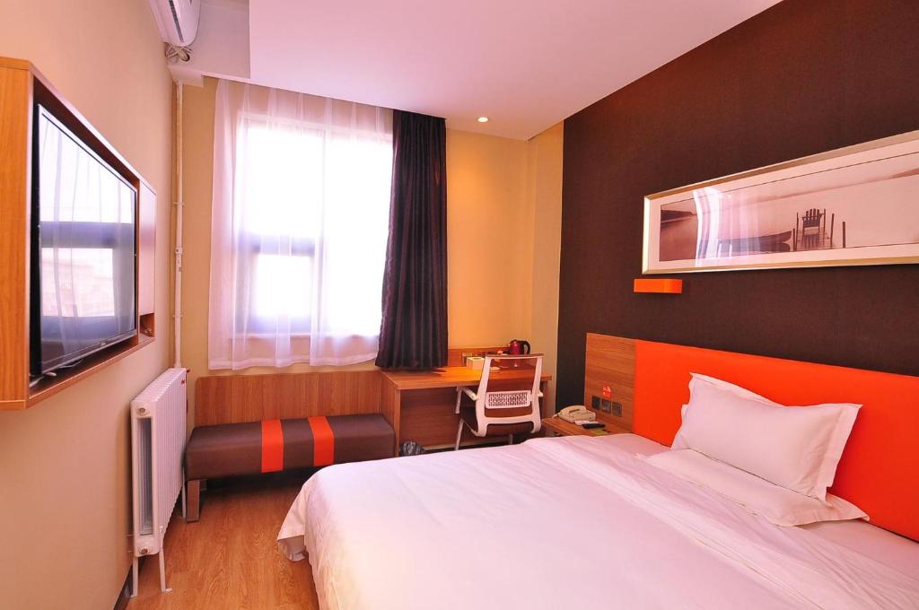 una camera con letto, scrivania e finestra di 7Days Premium Ji`nan Luokou Clothing City Wuying Hill North Road a Jinan
