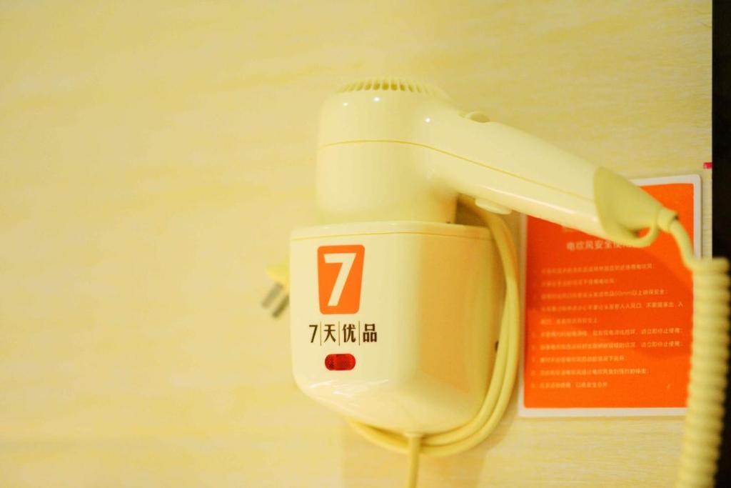 - un sèche-cheveux blanc accroché au mur dans l'établissement 7Days Premium Dalian Lvshun Central Square New Mart, à Dalian