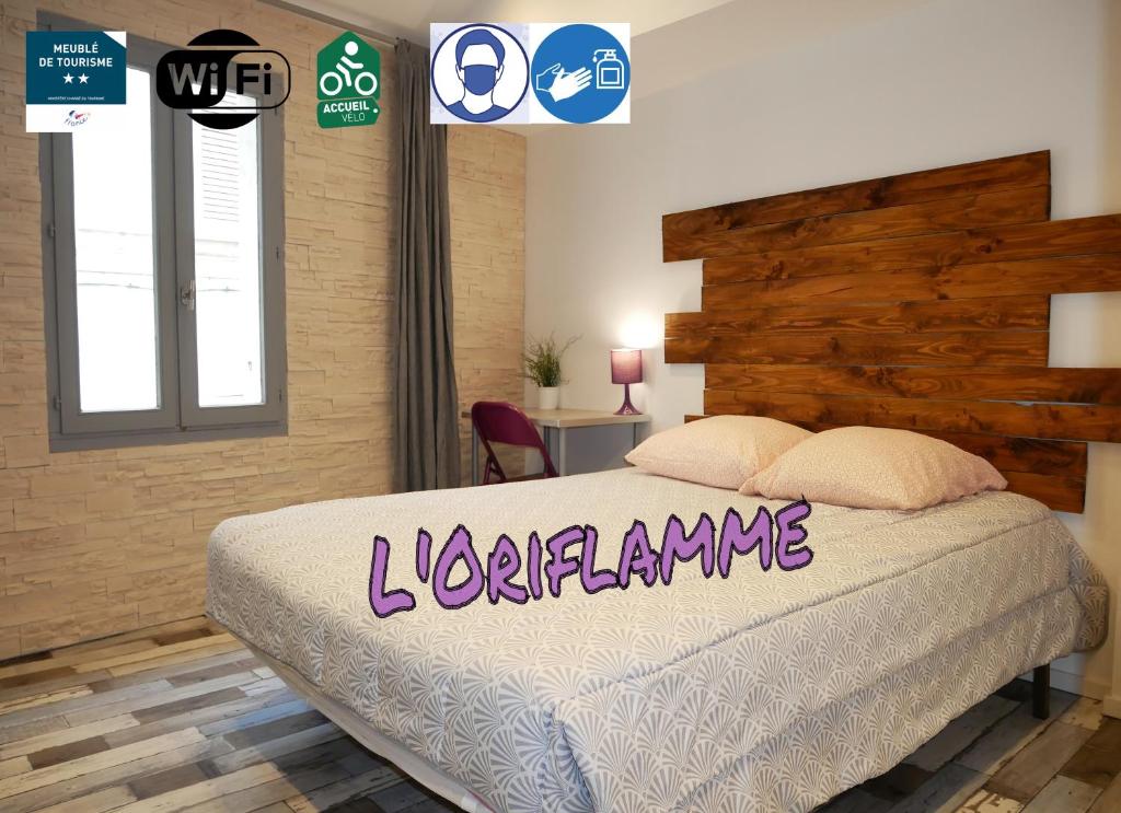 a bedroom with a large bed with a wooden headboard at L'Oriflamme in Avignon