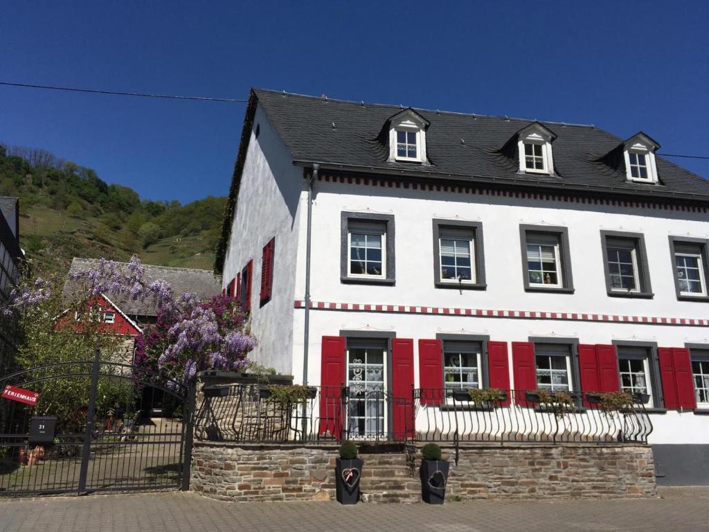 a white and red house with a black roof at Alter Winzerhof in Hatzenport