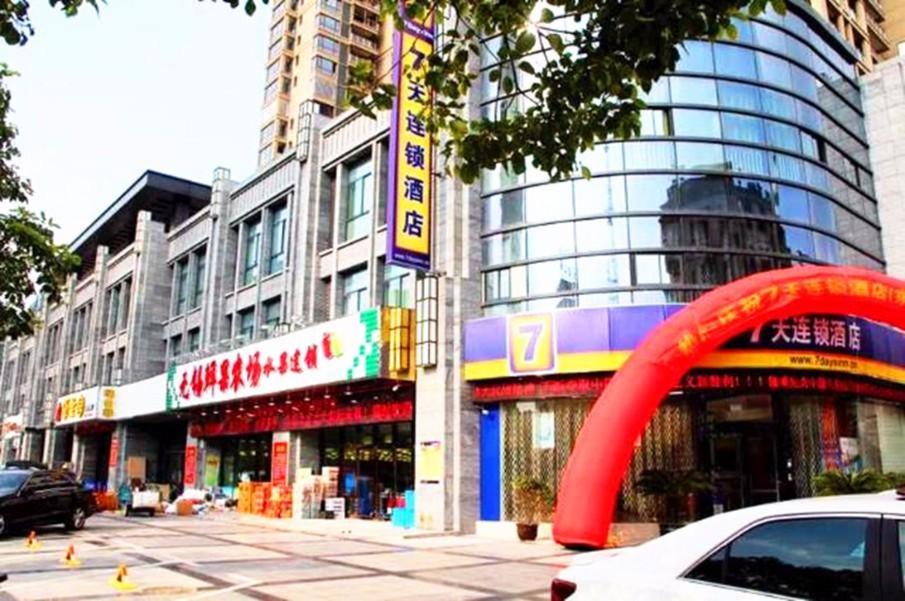 a building with a red arch in front of it at 7Days Inn Dongtai Hong Lan Road RT-Mart in Dongtai