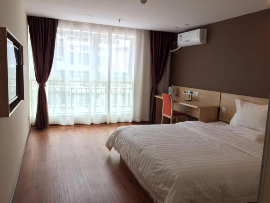 um quarto de hotel com uma cama, uma secretária e uma janela em 7Days Inn Chongqing Penghu Pengshui Garden em Pengshui