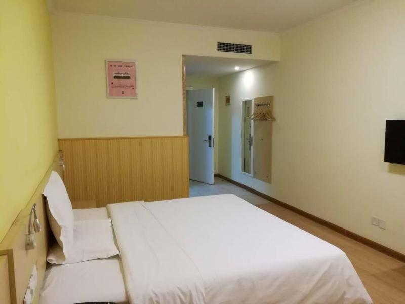 1 dormitorio con 1 cama blanca grande y TV en 7Days Inn Tianjin Zhongshan Road North Station, en Tianjin