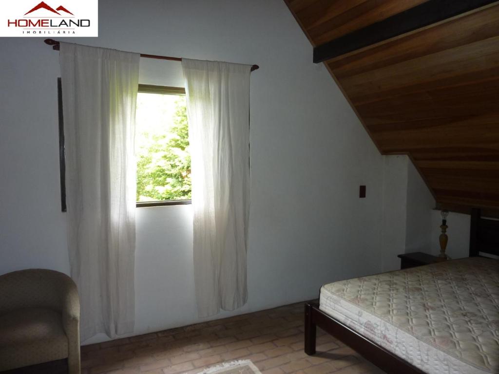 a bedroom with a bed and a window at Alugo linda casa de campo perto de São Paulo com ótimo jardim, piscina e lareira. in Sará-Sará
