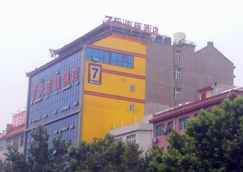 a yellow building with a sign on the side of it at 7Days Inn Longmen Grottoes of Luoyang Kaiyuan Avenue in Luoyang