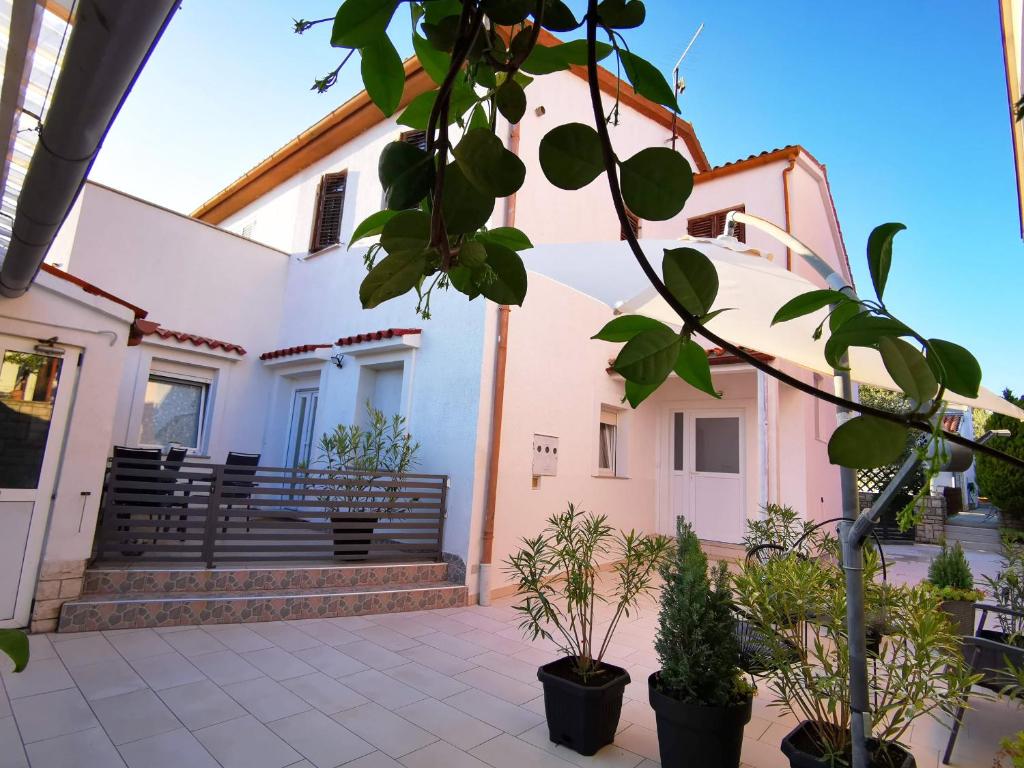 a building with potted plants in front of it at Apartment Dante in Fažana