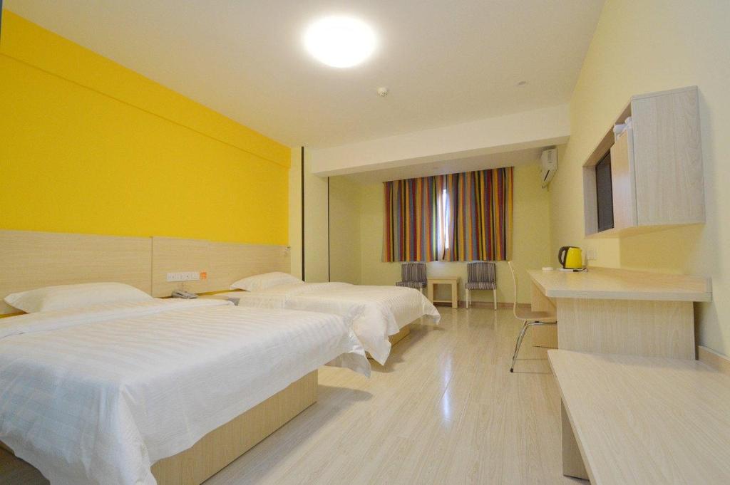ein Hotelzimmer mit 2 Betten und einer gelben Wand in der Unterkunft 7Days Inn Nanjing Confucius temple Yudaojie in Nanjing
