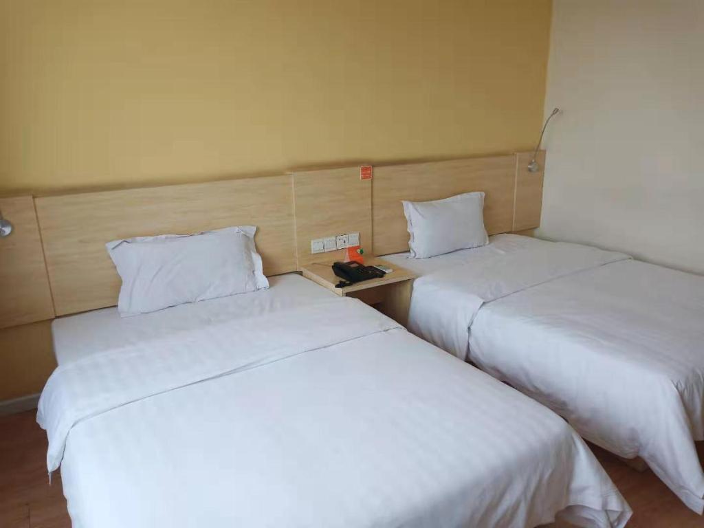 Кровать или кровати в номере 7Days Inn Zibo Dongsi Road Shengshi Xincheng