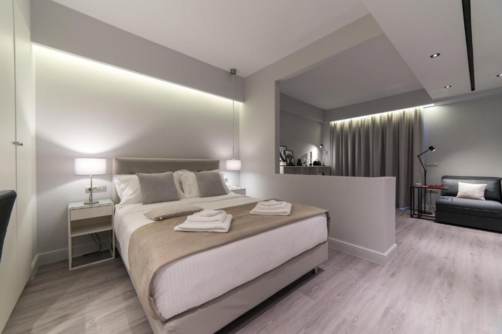 a bedroom with a large bed and a living room at JB Luxury Suites in Nafplio