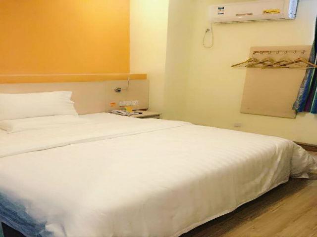 Un dormitorio con una gran cama blanca en una habitación. en 7Days Inn Suzhou Xuguan, en Suzhou
