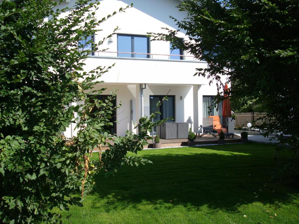 ein weißes Haus mit einem Garten mit grünem Gras in der Unterkunft Ferienwohnung Krause in Oberammergau