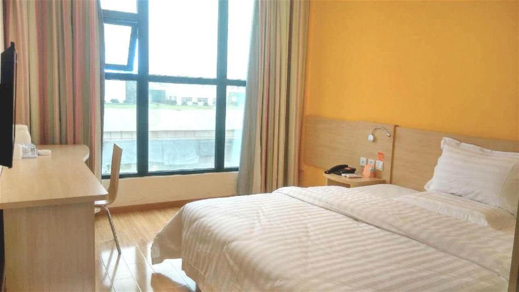 a hotel room with a bed and a window at 7Days Inn Langzhong Seven Mile Avenue in Langzhong