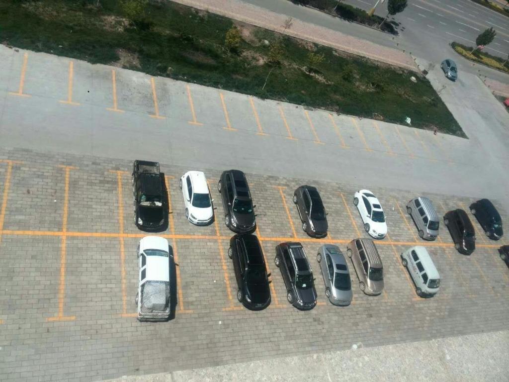 un groupe de voitures garées sur un parking dans l'établissement 7Days Inn Aksu Airport, à Wensu