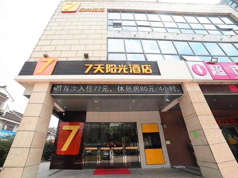 een gebouw met een bord aan de voorkant bij 7Days Inn Suzhou Industrial Park Sheng Pu Tongjiang Road in Suzhou