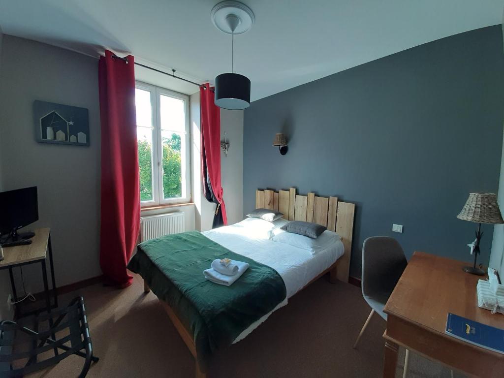 1 dormitorio con cama, escritorio y ventana en L'Auberge du Tire Bouchon, en Couffé