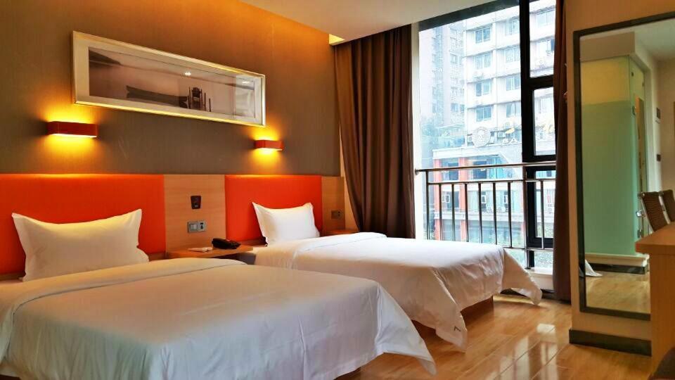 a hotel room with two beds and a large window at 7Days Premium Chongqing Fuling Riverside Avenue in Fuling