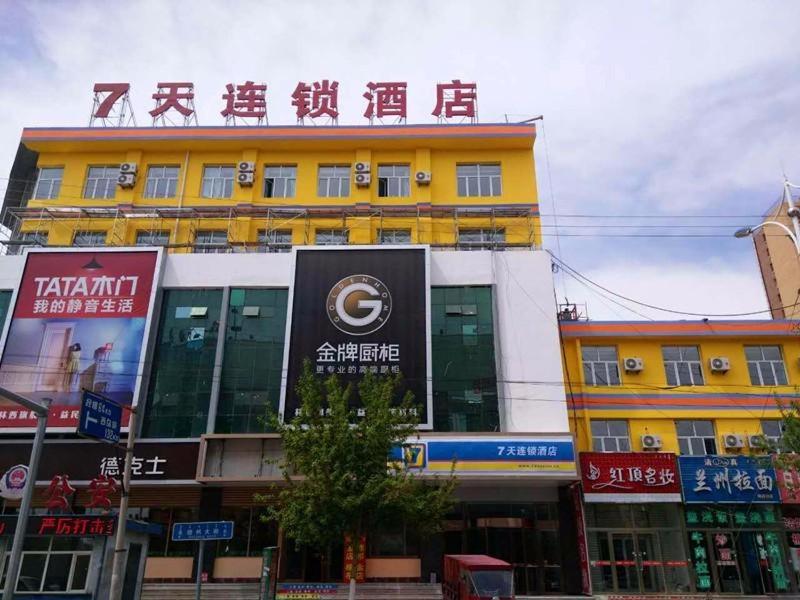 un bâtiment jaune avec un panneau en haut dans l'établissement 7Days Inn Chifeng Linxi Haichuan Square Branch, à Linxi