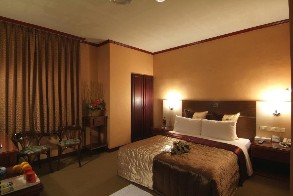 新竹市的住宿－金燕精緻旅館，酒店客房带一张床、一张桌子和椅子