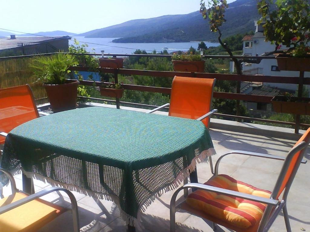 uma mesa e cadeiras num pátio com vista para a água em Apartment Marino - large terrace em Marina