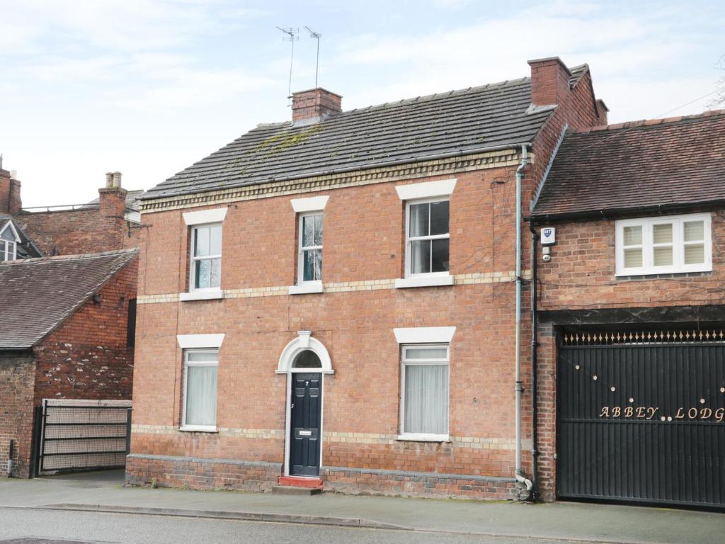 an old brick house with a black garage at 7 Monkmoor Road in Shrewsbury
