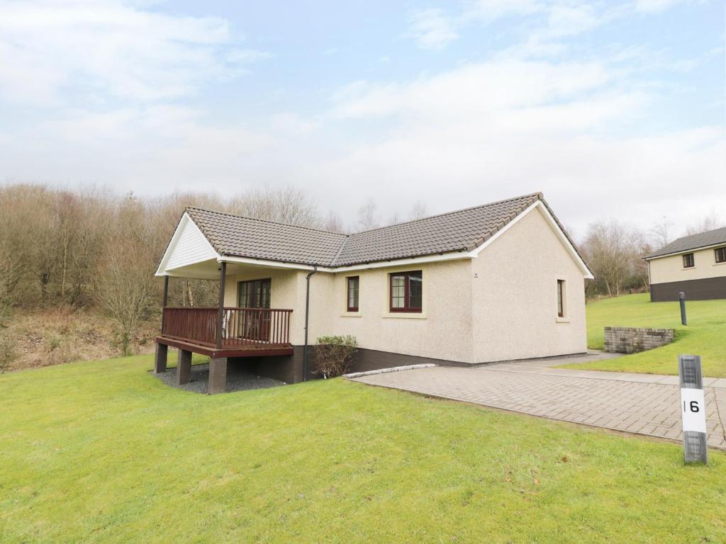 een wit huis met een terras op een erf bij Savita Cottage in Girvan