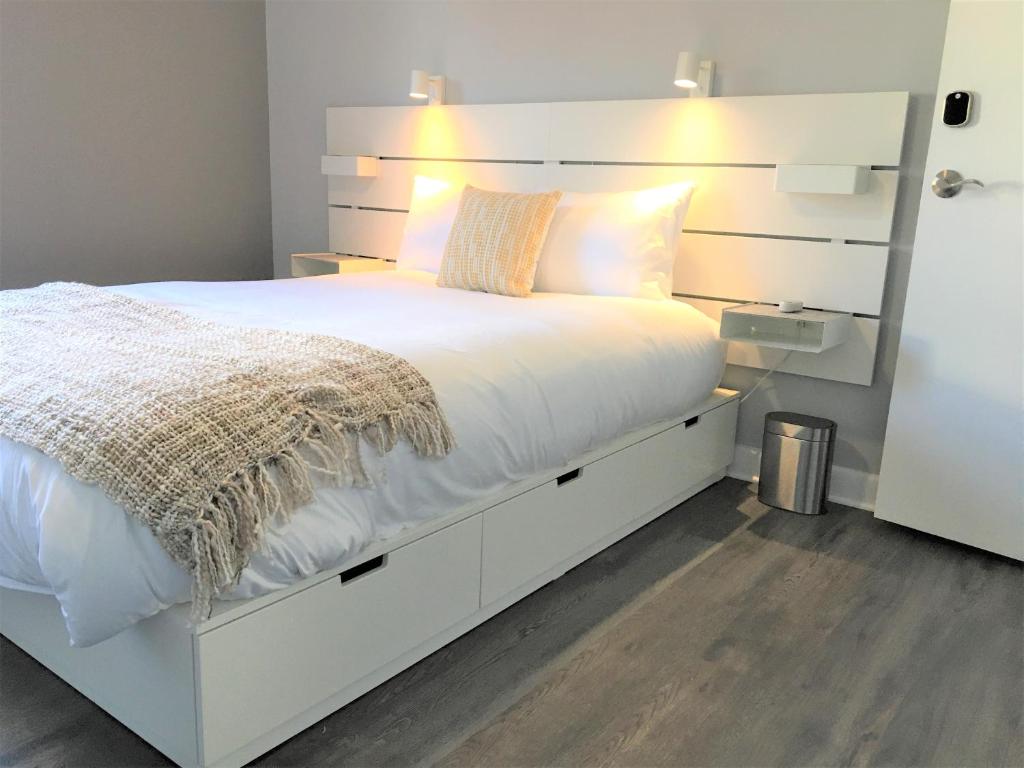 a bedroom with a white bed with a white headboard at Simply Stays in Ottawa