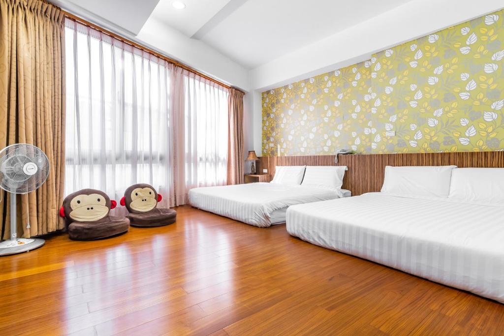a hotel room with two beds and a fan at Starry Home in Xiaoliuqiu