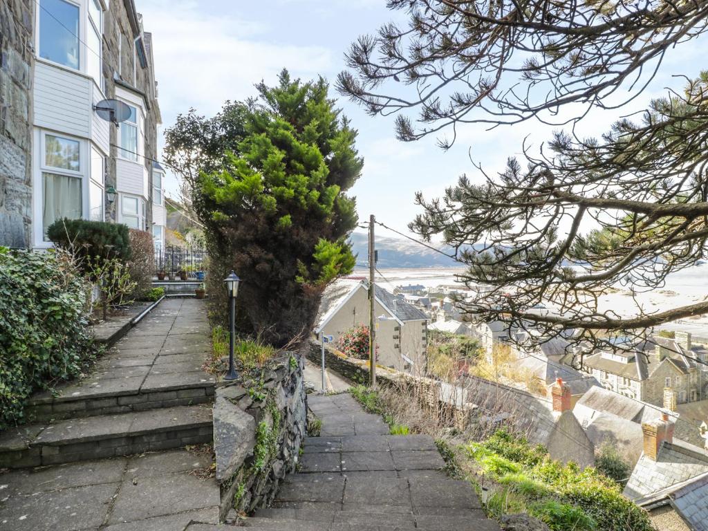 a stairway leading up to a house with a tree at Seaview Apartment in Barmouth