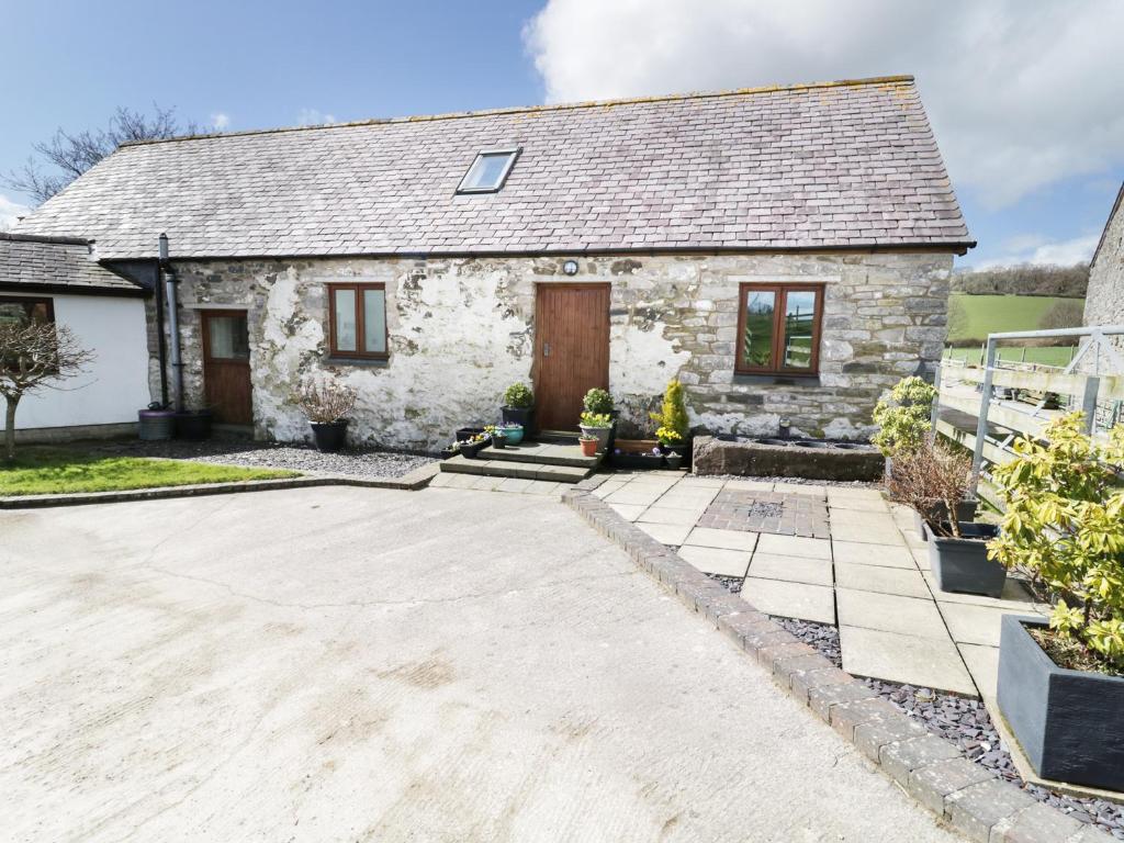 a stone house with a driveway in front of it at Tyddyn Isa in Denbigh